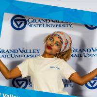 individuals smiling with frame and tan i am grand valley shirt
